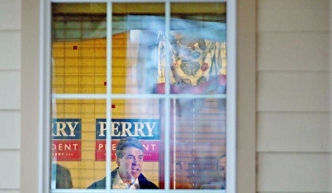 Texas Gov. Rick Perry is seen through a window as he delivers a stump speech during a campaign stop at Lizard&#x27;s Thicket restaurant in Lexington, S.C., on Wednesday. (Associated Press)