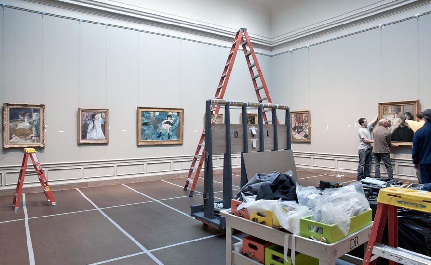 Handlers hang paintings in the National Gallery of Art's newly re-installed 19th-century French galleries. (Photograph courtesy National Gallery of Art)