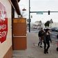 **FILE** Three young girls walk past the Med Stop marijuana dispensary in Denver, located across from Del Pueblo Elementary School, on Jan. 12, 2012. (Associated Press)