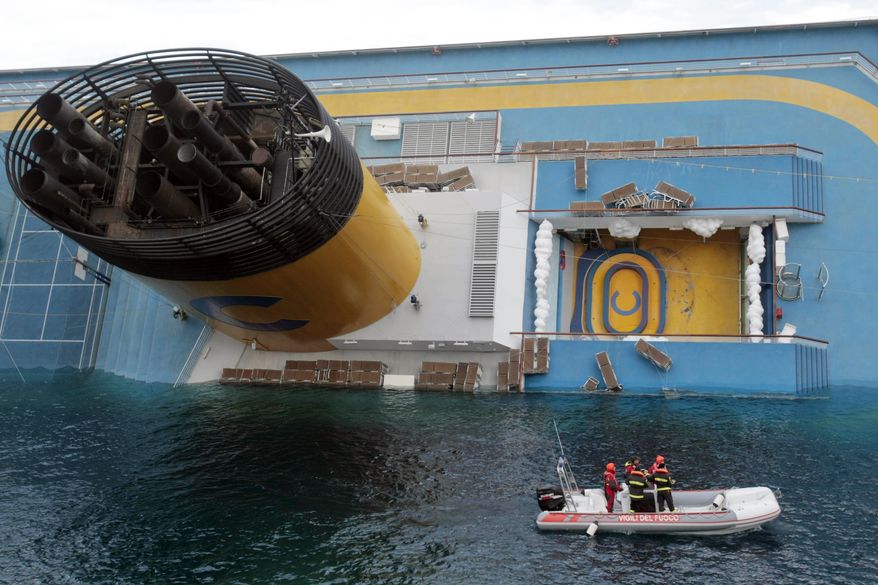 Italian firefighters scuba divers approach the cruise ship Costa Concordia leaning on its side, the day after it ran aground off the tiny Tuscan island of Giglio, Italy, Sunday, Jan. 15, 2012. A helicopter on Sunday airlifted a third survivor from the capsized hulk of a luxury cruise ship 36 hours after it ran aground off the Italian coast, as prosecutors confirmed they were investigating the captain for manslaughter charges and abandoning the ship. (AP Photo/Gregorio Borgia)