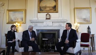 British Prime Minister David Cameron (right) speaks with Palestinian Authority President Mahmoud Abbas during their meeting at 10 Downing Street in London on Monday, Jan. 16, 2012. The woman at left is unidentified. (AP Photo/Lefteris Pitarakis, Pool)