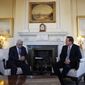 British Prime Minister David Cameron (right) speaks with Palestinian Authority President Mahmoud Abbas during their meeting at 10 Downing Street in London on Monday, Jan. 16, 2012. The woman at left is unidentified. (AP Photo/Lefteris Pitarakis, Pool)