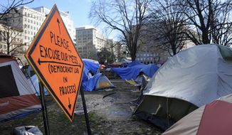 An Occupy DC protestor&#39;s sign and tents sit in McPherson Square Park in Washington, Friday, Jan. 13, 2012. (AP Photo/Cliff Owen)