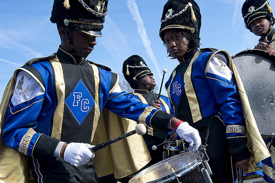Diamante Scott, 17, left, tunes a drum while his fellow Friendship Collegiate Academy drumline members (from left) Shianell Dunn, 16, Kadesha Ransom, 17, and Ronal Greene, 14, wait for the Martin Luther King Jr. Day Parade along Martin Luther King Jr. Avenue in Southeast Washington, D.C. to begin on Monday, Jan. 16, 2012. This is the first time in eight years that the parade has been held, and more than 200 groups signed up to march. (Barbara L. Salisbury/The Washington Times)