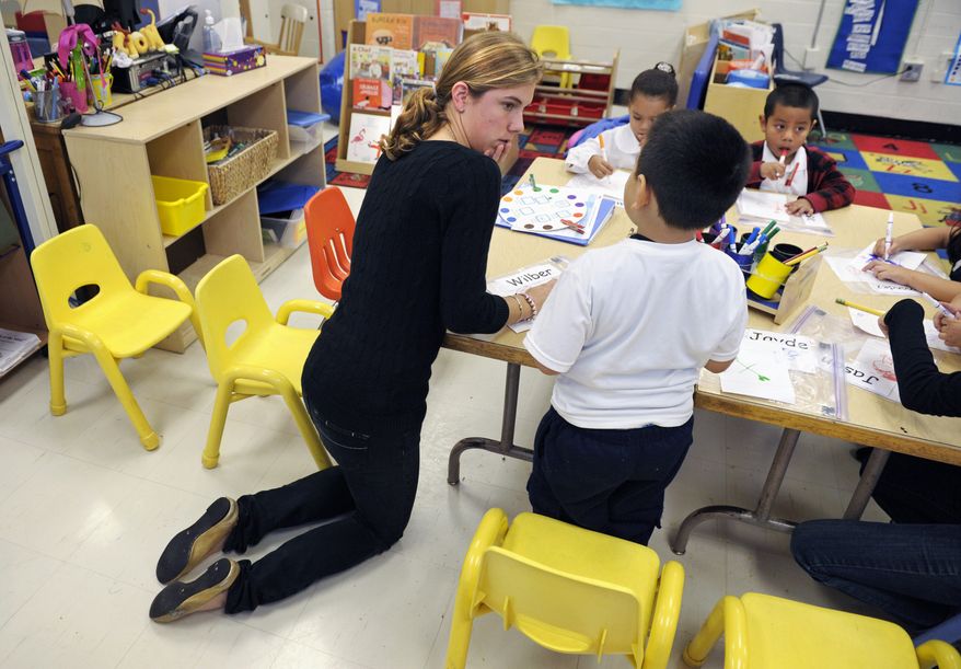 Pre-kindergarten teacher Laura Amling helps her 3-year-old students with a project at Powell Elementary School in Washington on Dec. 6, 2011. The expansion in public prekindergarten programs has slowed and even been reversed in some states as school districts cope with shrinking budgets. As a result, many 3- and 4-year-olds aren't going to preschool. (Associated Press)