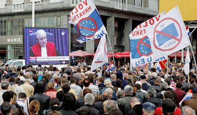 Residents wave anti-EU flags as they watch a live broadcast from the U.N. court on the verdict for a key wartime Croatian commander, Gen. Ante Gotovina, in Zagreb, Croatia, in April. Croatia signed an EU accession treaty last year and is set to become a member in July 2013, if the Croats say &quot;yes&quot; in the referendum and all of the bloc&#39;s 27 states later ratify the deal. (Associated Press)