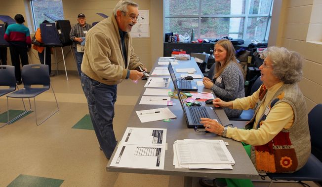 Thomas Pounds of Anderson, S.C., checks in to vote in the South Carolina Republican primary with poll manager Mae Kellam (right) at the Anderson Recreation Center in Anderson, S.C., on Saturday, Jan. 21, 2012. (AP Photo/Anderson Independent-Mail, Ken Ruinard)