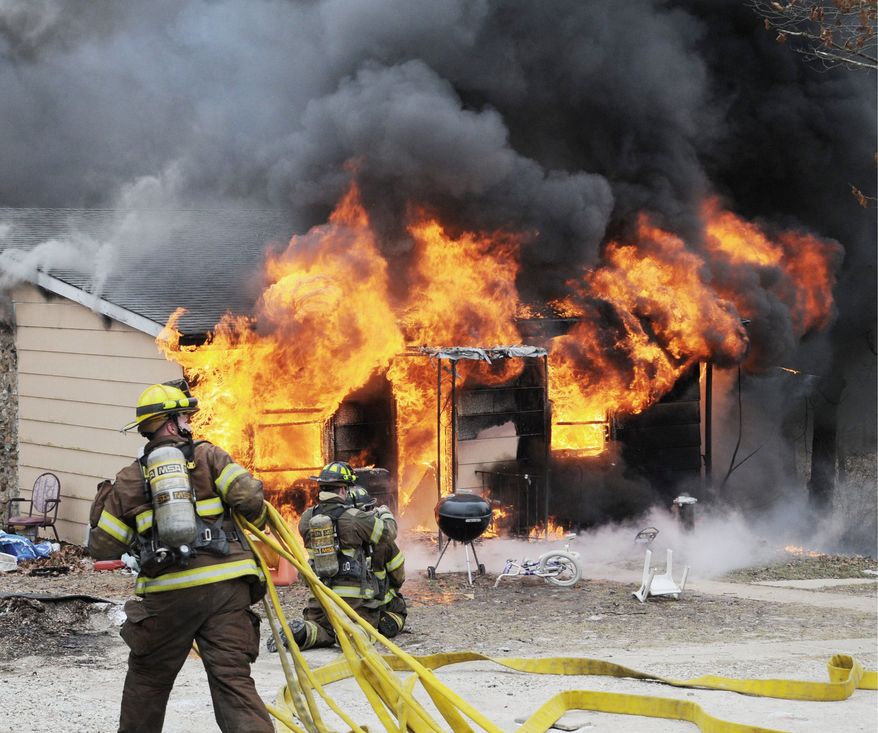 Firefighters battle a blaze from a shake-and-bake meth-lab explosion in 2010 at a house in Union, Mo. The crude new method of making methamphetamine, by combining raw and unstable ingredients in a 2-liter soda bottle, poses great risks. The concoction can explode, burning the user. (Associated Press)