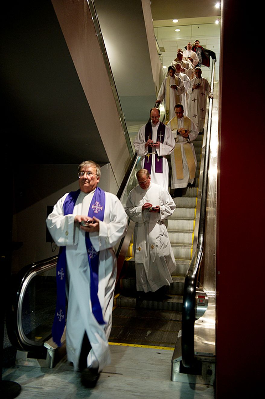 Priests come down the escalator at the Verizon Center in Washington, D.C. after administering communion to the thousands of people in attendance at the Youth Rally and Mass for Life Monday, Jan. 23, 2012. Donald Wuerl, archbishop of Washington, celebrated the mass. This year there was an overflow mass at the D.C. Armory. (Barbara L. Salisbury/The Washington Times)