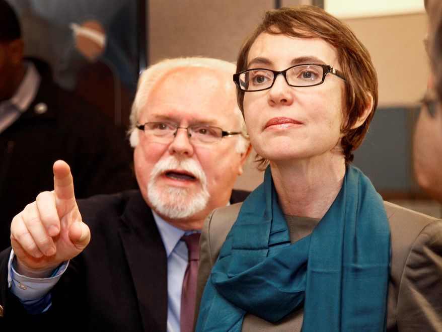 Rep. Gabrielle Giffords, Arizona Democrat, tours the Gabrielle Giffords Family Assistance Center in Tucson, Ariz., on Monday with staffer Ron Barber. It was one of her last acts as a congresswoman before stepping down this week to focus on her recovery from a gunshot to the head last year. (Associated Press)