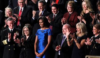 First lady Michelle Obama stands among several guests of the White House at the State of the Union address in this 2012 file photo. In the front row (from left) are Adm. William McRaven; Jackie Bray; Mrs. Obama; retired Navy Capt. Mark Kelly; Jill Biden, wife of the vice president; and Sgt. Ashleigh Berg. Two of the celebrity guests were Debbie Bosanek (second row with glasses), longtime secretary to billionaire Warren Buffett, and Laurene Powell Jobs (second row right with blond hair), widow of Apple co-founder Steve Jobs. (Associated Press) ** FILE **