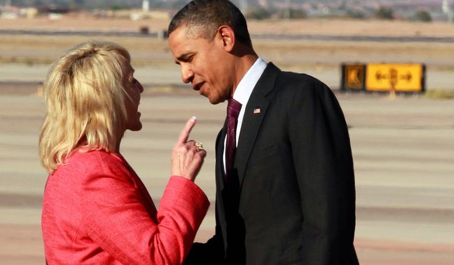 Arizona Gov. Jan Brewer makes a point to President Obama upon his arrival Wednesday at Phoenix-Mesa Gateway Airport. Mrs. Brewer said he took issue with a passage in her book that described an encounter in an unflattering manner. (Associated Press)