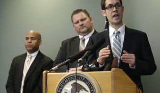 Assistant U.S. Attorney Darwin Roberts, right, talks to reporters as Kelly Kneifl, center, who had his home broken into by Barefoot Bandit Colton Harris-Moore, and FBI Agent Steven Dean, left, look on, Friday, Jan. 27, 2012, following the federal sentencing hearing for Harris-Moore in Seattle. (AP Photo/Ted S. Warren)
