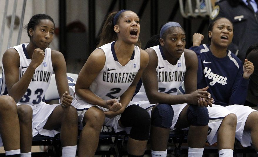 Georgetown forward Brittany Horne, left, forward Tia Magee (2) and others cheer their teammates in a game against Syracuse in Washington, Sunday, Jan. 15, 2012. Georgetown beat Syracuse 69-42. (AP Photo/Ann Heisenfelt)