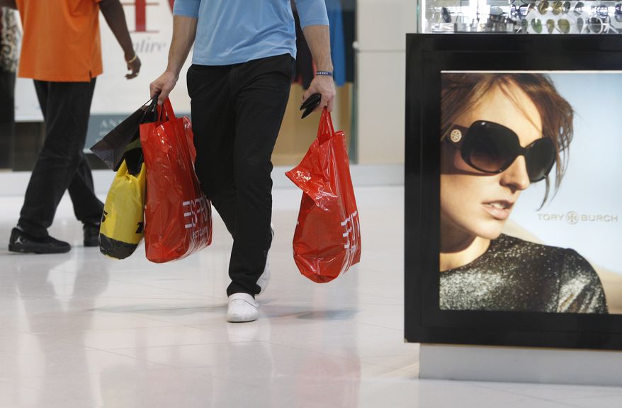A shopper carries purchases Nov. 9, 2011, while shopping at Dolphin Mall in Miami. (Associated Press)