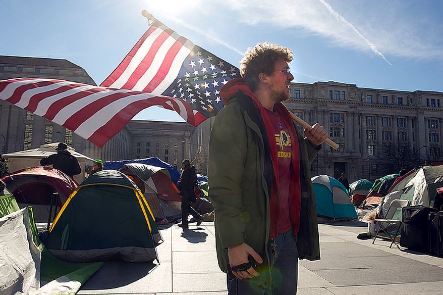 James McPherson of Norfolk, Va., stands with his upside-down American flag at the Freedom Plaza Occupy encampment in Washington, D.C. on Monday, Jan. 30, 2012, the day that Park Police said they would begin to enforce the no camping laws. In anticipation, Occupiers have cleaned out their tents and removed any sleeping bags and pillows. As of 1:30 p.m. no police had shown up. (Barbara L. Salisbury/The Washington Times)