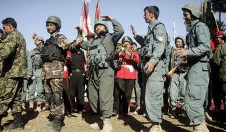 Afghan security forces celebrate Tuesday during a ceremony transferring authority from NATO-led troops to them in an area west of Kabul. The turnover to Afghan troops and police is to be finished by 2014. (Associated Press)