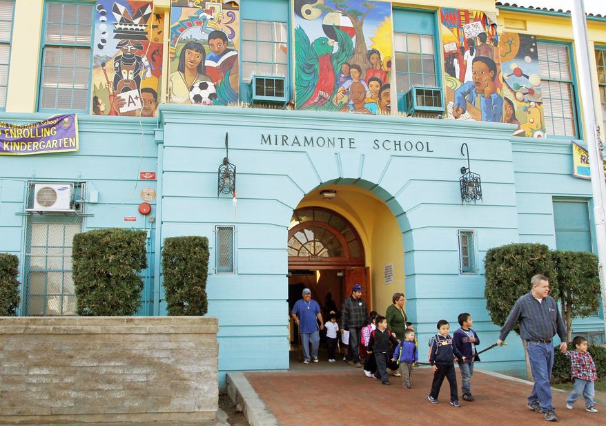 Students are escorted to the bus Tuesday as they leave Miramonte Elementary School in Los Angeles. (Associated Press)