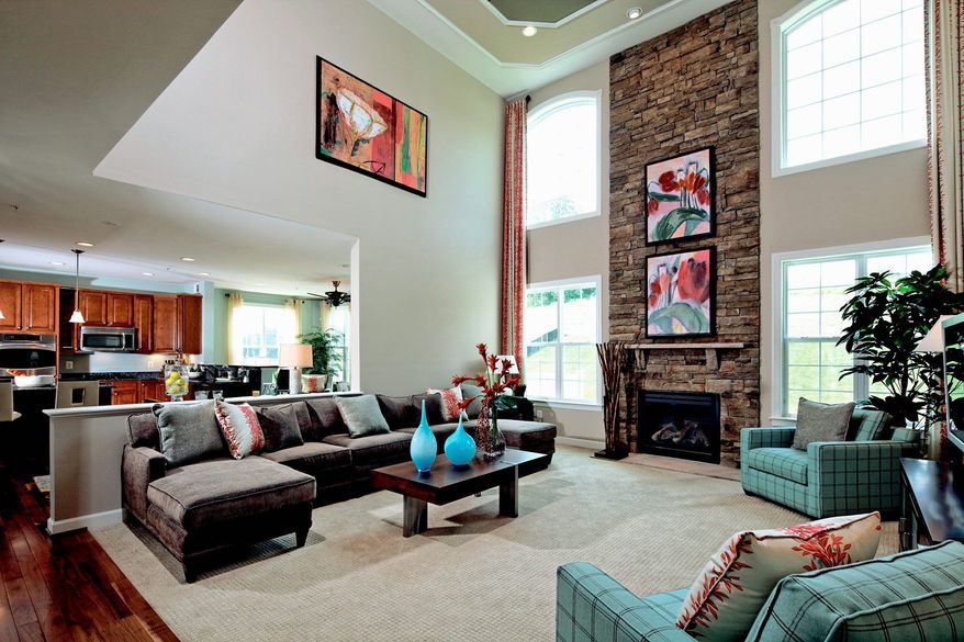 The Delaware model has a two-story family room with a fireplace flanked by floor-to-ceiling windows. The family room is adjacent to the kitchen.