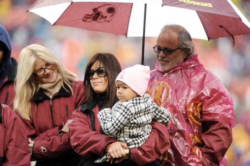 Sean Taylor's girlfriend, Jackie Garcia, holds their daughter, Jackie, during a pregame tribute to the slain Washington Redskins safety in November 2008. Taylor (right) was fatally shot the year before. (The Washington Times)