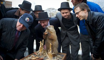 Mike Silverstein (in Steelers cap), Andy Klingenstein (second from left), Will Stephens (third from left), D.C. Council member Jack Evans (fourth from left), Aaron DeNu (third from right), Andrew Huff (second from right) and Kevin O&#x27;Connor pretend to listen for the &quot;predictions&quot; of Potomac Phil during the inaugural Groundhog Day event at Dupont Circle in Washington on Thursday, Feb. 2, 2012. (Rod Lamkey Jr./The Washington Times)