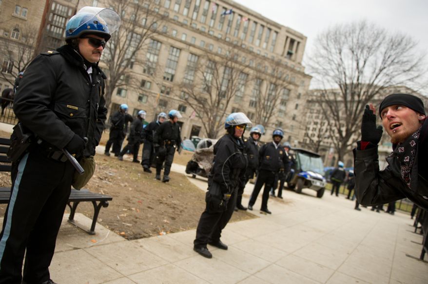 A protesters leans across a barrier to taunt a park police officer during a raid on the Occupy encampment at McPherson Square, Washington, D.C., Saturday, Feb. 4, 2012. Police and protesters clashed throughout the day as tents and camping equipment were removed by park police and maintenance officials, some dressed in hazmat suits.(Andrew Harnik/The Washington Times)