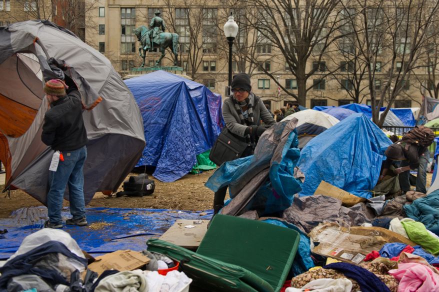 Michael Basillas of San Diego, Calif., center, and other protesters pack up their belongings during a raid on the Occupy encampment at McPherson Square, Washington, D.C., Saturday, Feb. 4, 2012. (Andrew Harnik/The Washington Times)