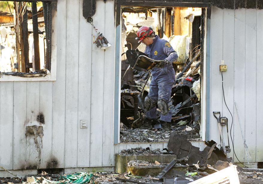 ASSOCIATED PRESS PHOTOGRAPHS
A fire investigator works his way through charred rubble on at the home where Josh Powell and his two sons were killed Sunday, in Graham, Wash., in what police said appeared to be a deliberately set fire.