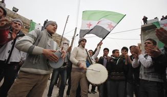 Anti-Syrian regime protesters play drums and wave a revolutionary flag Feb. 6, 2012, during a demonstration in Idlib, Syria. (Associated Press)