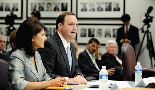 ** FILE ** South Carolina Attorney General Alan Wilson, here with Gov. Nikki Haley in June, argues in a lawsuit filed in February that the U.S. Justice Department erred in blocking the state from requiring voters to show government-issued photo identification to vote. The requirement &quot;will not disenfranchise any potential South Carolina voter,&quot; he said. (Jeremy Lock/Special to The Washington Times)
