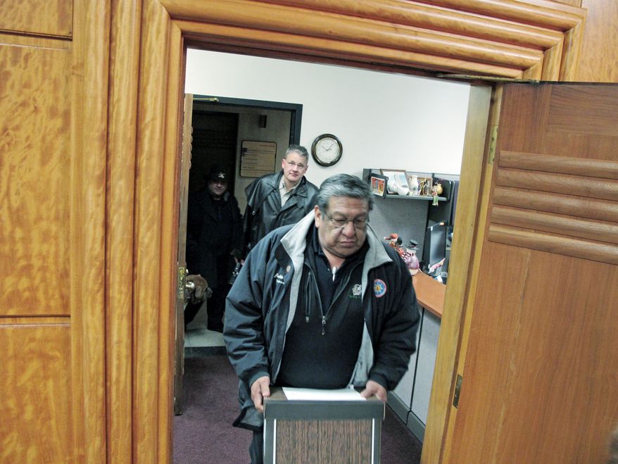 Archie Fool Bear, of Fort Yates, N.D., a former Standing Rock Sioux tribal council member, carries a box of petitions into the North Dakota Secretary of State's Office in Bismarck, N.D., on Tuesday. The petitions call for a vote on keeping the state university's Fighting Sioux nickname and logo. (Associated Press)