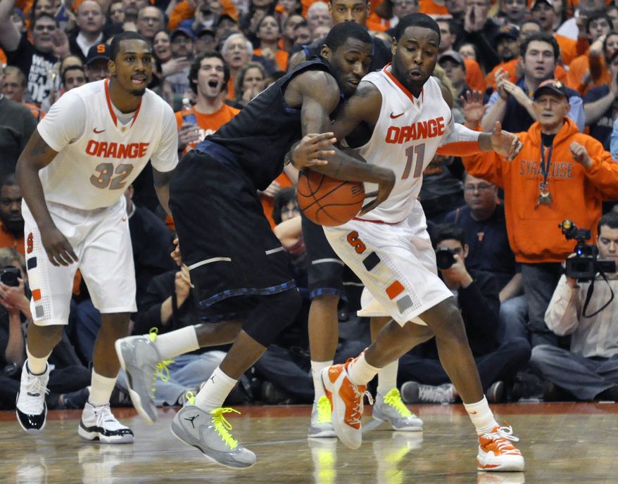 Syracuse's Scoop Jardine, right, knocks the ball loose from Georgetown's Jason Clark, forcing a turnover to end the game in overtime, in an NCAA basketball game in Syracuse, N.Y., Wednesday, Feb. 8, 2012. Syracuse won 64-61. (AP Photo/Kevin Rivoli)