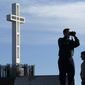 ** FILE ** The Rev. John Fredericksen (left) of Orlando, Fla., with Burdette Streeter of San Diego, takes a picture in front of the war memorial cross on Mount Soledad in San Diego in January 2011. (AP Photo/Gregory Bull)