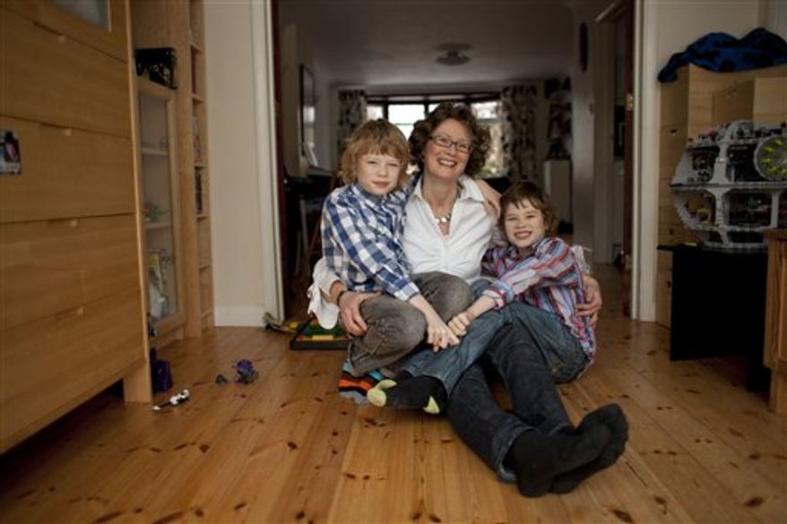 In this Thursday, Feb. 9, 2012 photo, Caroline Swain poses for photographs with her sons Max, left, 10, and Luke, 9, at their home in Rayleigh, England. Swain was diagnosed with breast cancer while pregnant with Luke. She had her left breast and many lymph nodes removed and had to wait until her fetus was 12-weeks-old before starting chemotherapy. Researchers have encouraging news for women who have cancer while pregnant. Studies suggest that these women can be treated almost the same as other cancer patients are, with minimal risk to the fetus. (AP Photo/Matt Dunham)