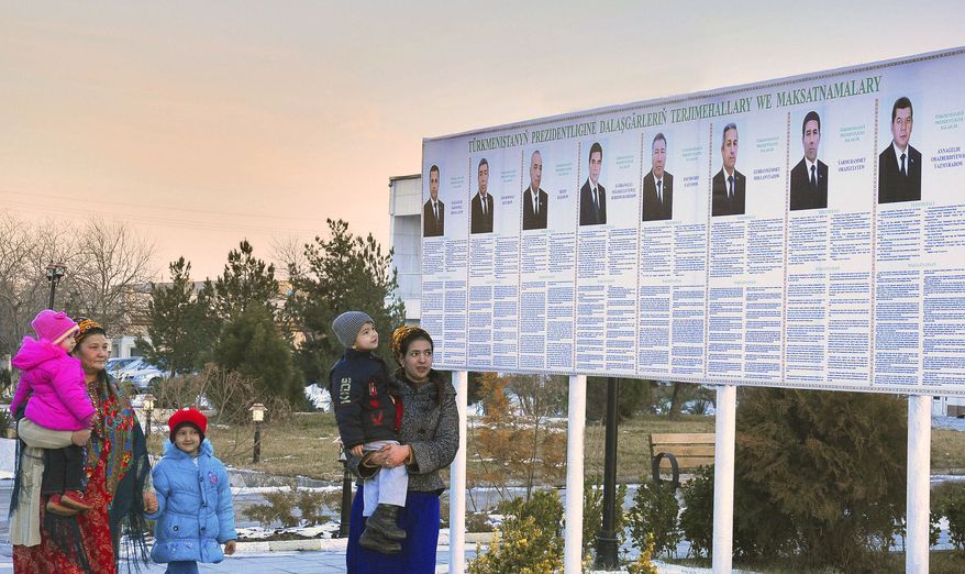 Residents look Feb. 7, 2012, at a presidential election poster depicting the candidates in Ashgabat, Turkmenistan. (Associated Press)