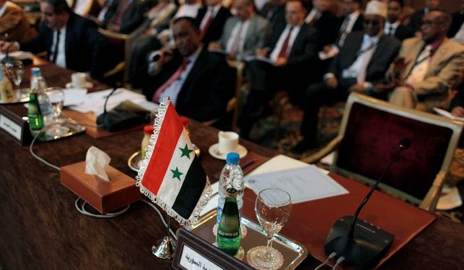 The Syrian flag and a sign in Arabic that reads &quot;the Syrian Arabic Republic&quot; mark the empty chair of the Syrian representative during the Arab League Syria Group and foreign ministers meeting Sunday in Cairo. The group is seeking to halt the bloodshed in the rebellion against President Bashar Assad. (Associated Press)