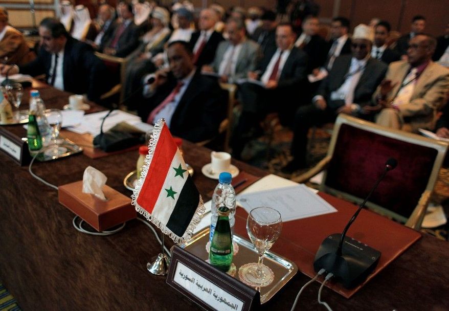 The Syrian flag and a sign in Arabic that reads "the Syrian Arabic Republic" mark the empty chair of the Syrian representative during the Arab League Syria Group and foreign ministers meeting Sunday in Cairo. The group is seeking to halt the bloodshed in the rebellion against President Bashar Assad. (Associated Press)