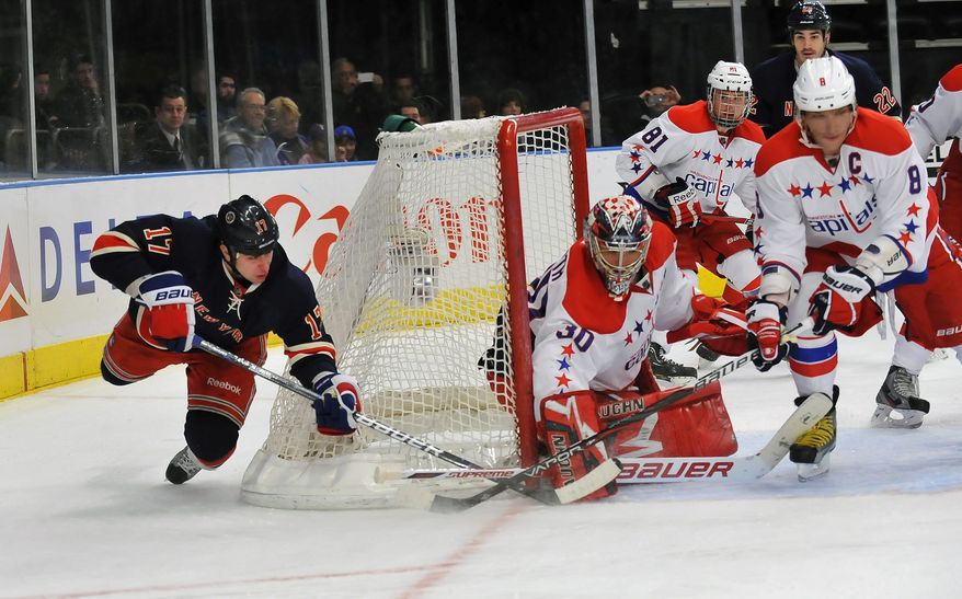 New York Rangers&#39; Brandon Dubinsky, left, tries a wraparound shot in the second period of an NHL game but the shot is blocked by Washington Capitals goalie Michal Neuvirth in New York, Sunday, Feb. 12, 2012. (AP Photo/Newsday, David Pokress)