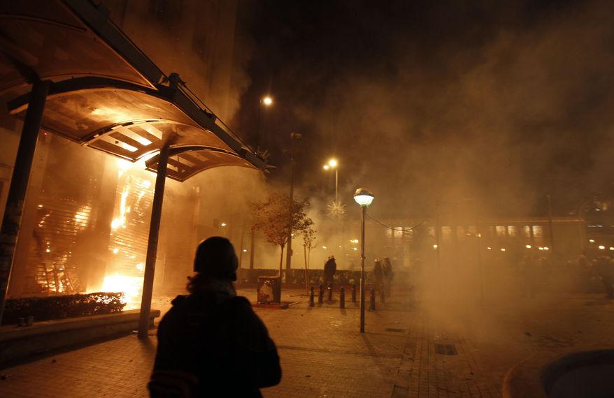A fire rages in a Eurobank branch that was set ablaze during riots in Athens on Sunday, Feb. 12, 2012. Protesters and police fought running battles in the city center as Greek lawmakers debated legislation that would introduce severe austerity measures to stave off bankruptcy. (AP Photo/Thanassis Stavrakis)
