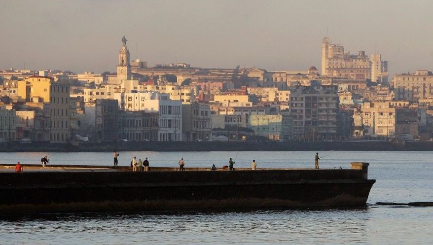 The city of Havana can be seen in the background as people fish from a dock in Havana Bay. The United States imposed an economic embargo on Cuba 50 years ago to pressure the regime of Fidel Castro. (Associated Press)
