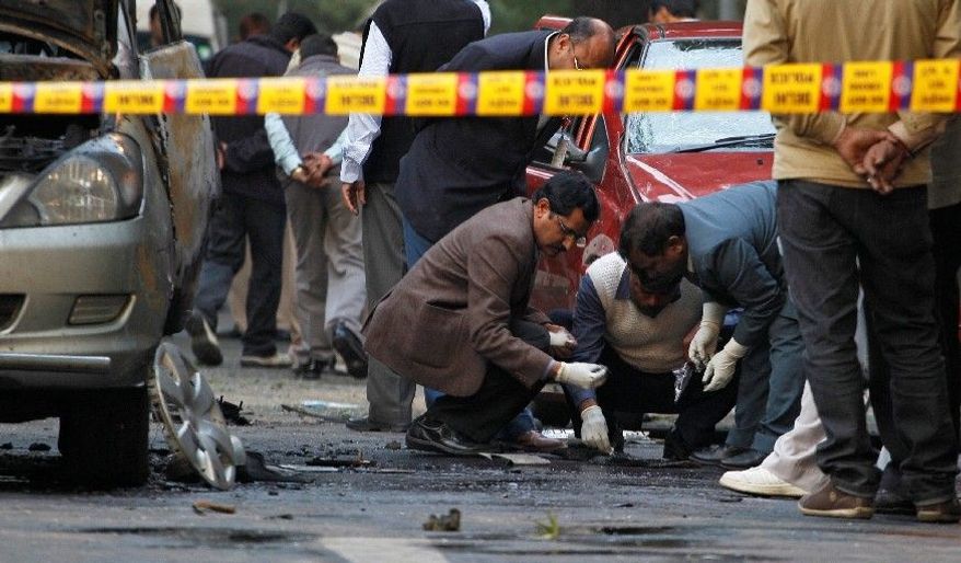 Indian security and forensic officials examine the spot where a bomb blew up an Israeli Embassy car. The attack was similar to ones on Iranian nuclear scientists. (Associated Press)