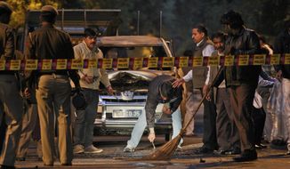 Indian police forensics experts collect evidence on Feb. 13, 2012, after an explosion tore through a car belonging to the Israel Embassy in New Delhi. Assailants targeted Israeli diplomats in India and Georgia in near-simultaneous strikes Monday that Israeli Prime Minister Benjamin Netanyahu blamed on archenemy Iran, and its Lebanese proxy, Hezbollah. (Associated Press)