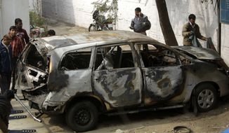 Police officers stand around an Israeli diplomat&#39;s car that was damaged in an explosion in New Delhi, India, Tuesday, Feb. 14, 2012. Indian investigators were searching Tuesday for the motorcycle assailant who attached a bomb to an Israeli diplomatic car in the heart of New Delhi in an attack the Jewish state blamed on Iran or its proxies. (AP Photo/Mustafa Quraishi)