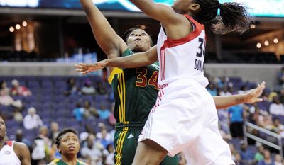 **FILE** Victoria Dunlap (right) of the Washington Mystics goes to the basket against the Seattle Storm&#39;s Le&#39;coe Willingham during the Storm&#39;s 73-63 home win on July 3, 2011. (Associated Press)