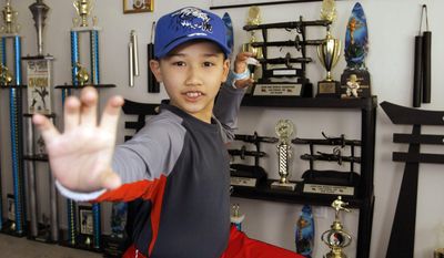 ** FILE ** In this May 2, 2008, file photo, Moshe Kai Cavalin, 10, strikes a martial arts position at his home studio in Downey, Calif. At age 11, Cavalin became the youngest person ever to earn an Associate in Arts degree from East Los Angeles College and now, at 14, is poised to graduate with honors from UCLA later this year. (AP Photo/Damian Dovarganes, File)