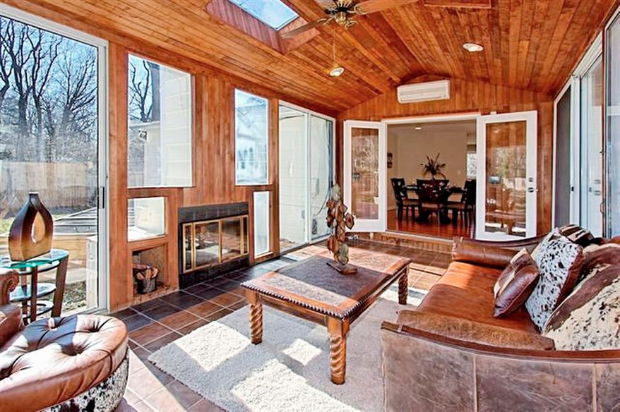 The sunroom has a wood ceiling, tile flooring and plenty of windows and sliding doors to let the outdoors inside. A fireplace keeps the room cozy.