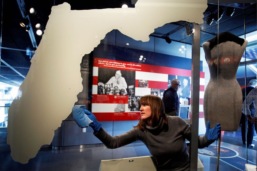 Emma Krebs, a collections technician with the Newseum, dusts a map of Florida, which played a pivotal role in the 2000 election. (Associated Press)