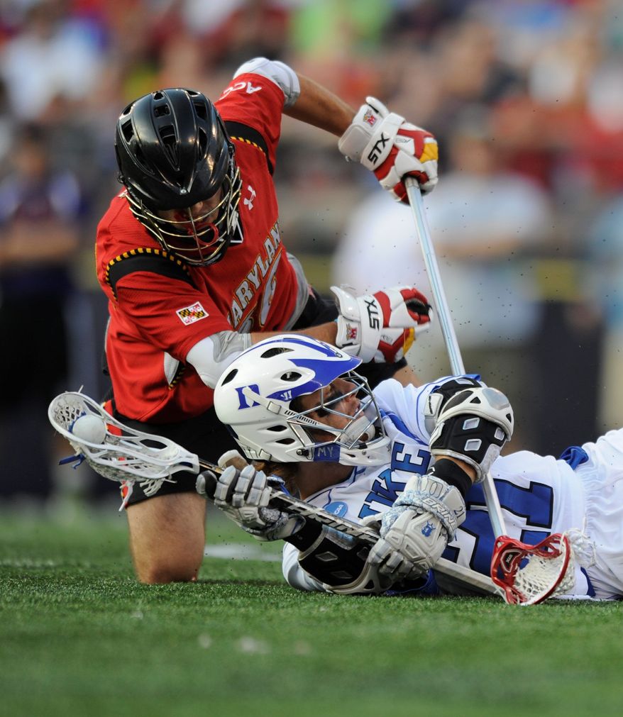 Duke's Zach Howell looks to pass after falling to the ground as Maryland's Jesse Bernhardt tries to take the ball in an NCAA Division I Lacrosse semi final game Saturday, May 28, 2011 in Baltimore.(AP Photo/Gail Burton)