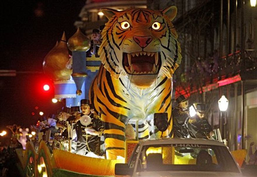 Revelers with the Mystic Stripers toss trinkets to the crowds gathered on Royal Street in Mobile, Ala., Thursday, Feb. 16, 2012. The pre-Lenten blowout continues along the Gulf Coast culminating in Fat Tuesday celebrations Feb. 21. Tourism leaders estimate more than a million visitors pour into the Mobile area each Mardi Gras season to watch the festivities. (AP Photo/Mobile Register, G.M. Andrews)