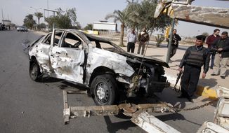 Security forces prepare to tow away a destroyed automobile after a car bombing outside the fortified police academy near the Interior Ministry headquarters in Baghdad on Sunday, Feb. 19, 2012. (AP Photo/Karim Kadim)